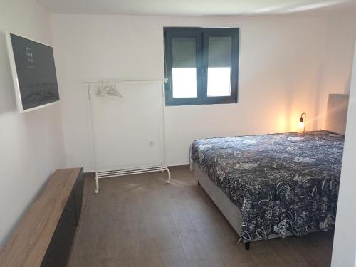 a bedroom with a bed and a window at Vikendica Coco in Gornja Toplica