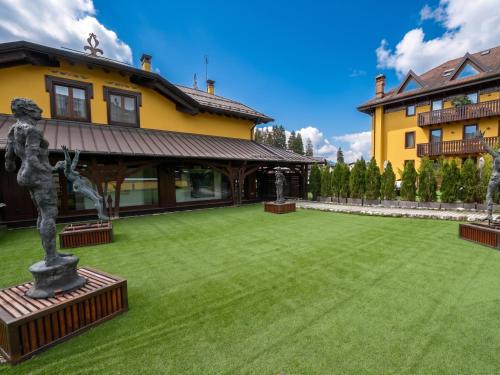 a courtyard with a statue in front of a building at Asiago Sporting Lodge - Buongiorno! Hotels in Asiago