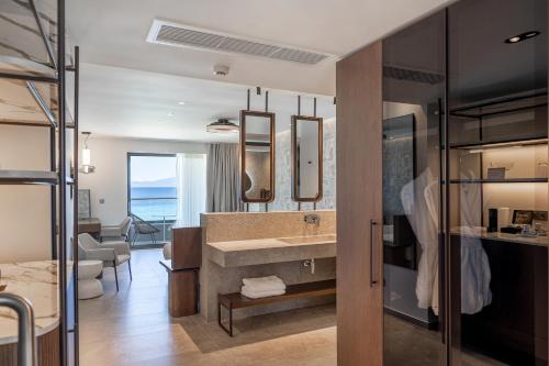 a bathroom with a sink and a large mirror at Margarita Sea Side Hotel in Kallithea Halkidikis