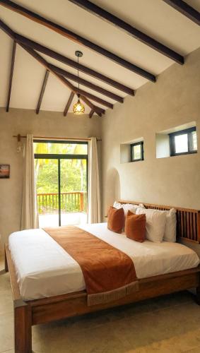 a bedroom with a large bed in front of a window at Mystic Beach Resort in Guachaca
