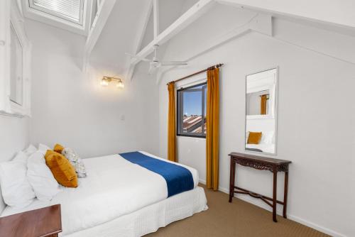 a white bedroom with a bed and a window at Charlesworth On The Park in Glen Innes