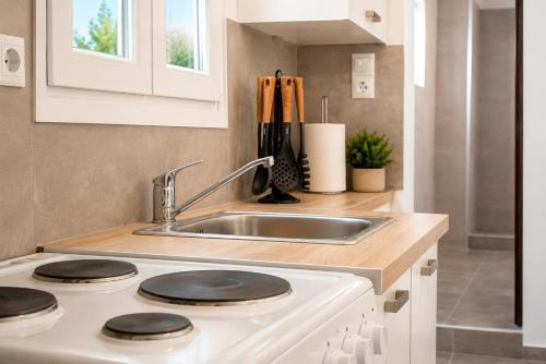 a kitchen with a sink and a stove at Dorothy's Apartments Near Athens Airport By SEM in Artemida