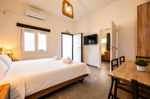 a bedroom with a large white bed and a table at Dorothy's Apartments Near Athens Airport By SEM in Artemida
