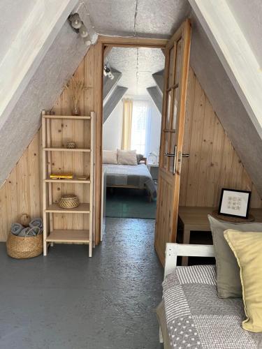 a attic room with a bed and a bedroom at Piejūras Namiņš in Ragaciems