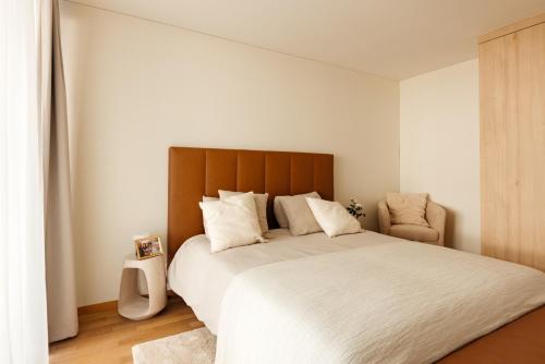 a bedroom with a large bed with a wooden headboard at Senevita Dreiklang in Lausen