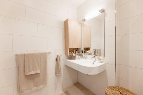 a white bathroom with a sink and a shower at Senevita Dreiklang in Lausen