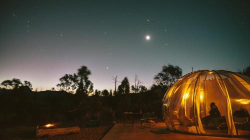 a couple of people in a dome tent at night at Bubble Hotel in Coonabarabran