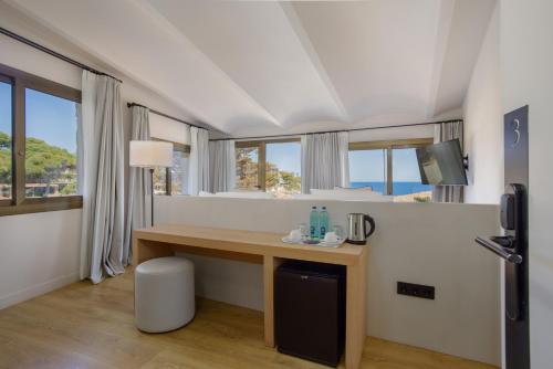 ein Zimmer mit Schreibtisch und Meerblick in der Unterkunft Eden Roc Hotel & Spa by Brava Hoteles in Sant Feliu de Guixols