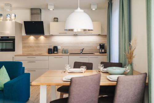 a kitchen with a wooden table and chairs at Am Park 15 in Prerow