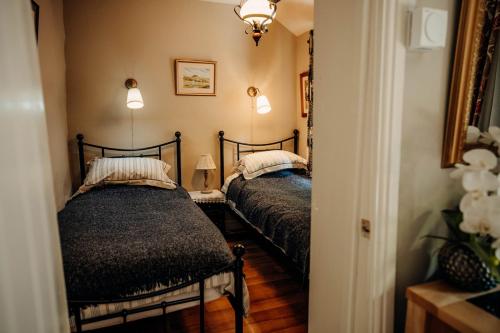 two beds in a room with a mirror at The Wilderness in Bromlow
