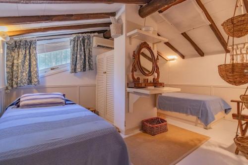 a bedroom with a bed and a mirror and a window at Villa Thalèa Fetovaia in Fetovaia