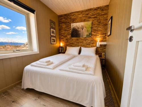 a bedroom with a large white bed with a window at Charming cabin with a view in Gol