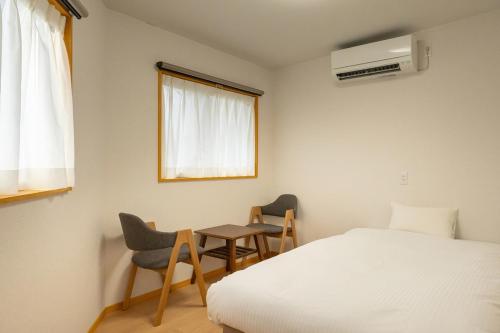 a bedroom with a bed and a table and chairs at 萩別邸 翠 HAGI Bettei SUI in Hagi