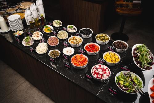 a table topped with lots of bowls of food at Focus Hotel Poznań in Poznań