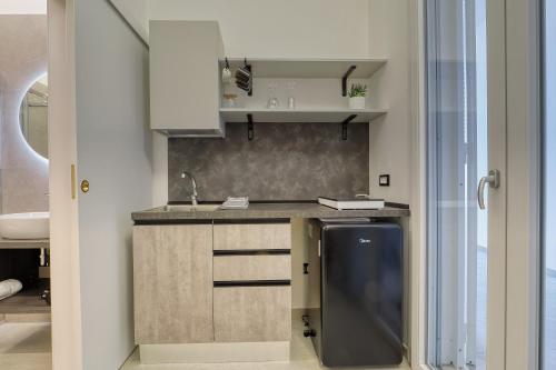 a kitchen with a sink and a counter with a tv at Agrù - Salento Garden Stay in Cavallino di Lecce