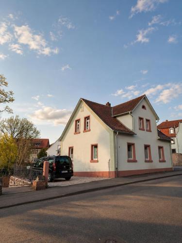 ein weißes Haus an einer Straßenseite in der Unterkunft Odenwaldperlchen in Michelstadt