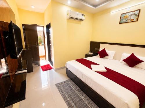 a bedroom with a large bed and a television at Hotel Hanumat Palace-300 meter Jaipur junction & 1km Sindhi camp bus stand in Jaipur