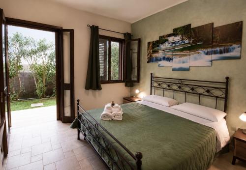 a bedroom with a large bed with a green blanket at Agriturismo Caranna in Torre Lapillo