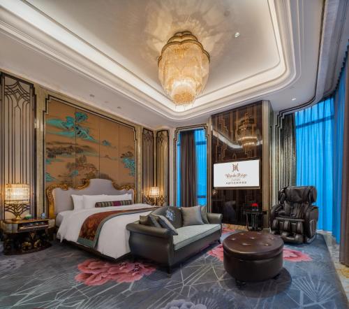 a bedroom with a large bed and a chandelier at Wanda Reign Chengdu in Chengdu