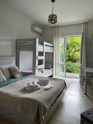 a bedroom with a bed and a large window at Guest house Junona in Makhinjauri