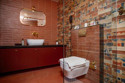 a bathroom with a toilet and a sink and a mirror at SVS Arena in Kizhake Chālakudi