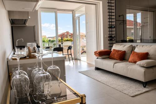 a living room with a couch and a table with glass vases at GM House - Appartamento luminoso con grande terrazza vicino Torino in Collegno