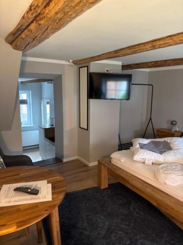 a living room with a bed and a table at Allenberghütte Schoningen in Uslar