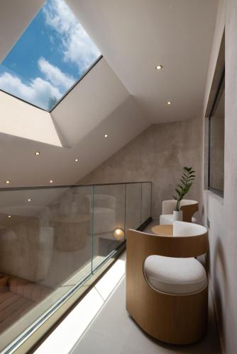 a skylight in a room with a chair and a table at Nomade Villas in Agios Ioannis Peristerion