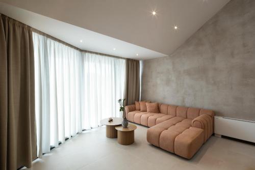 a living room with a couch and a large window at Nomade Villas in Agios Ioannis Peristerion
