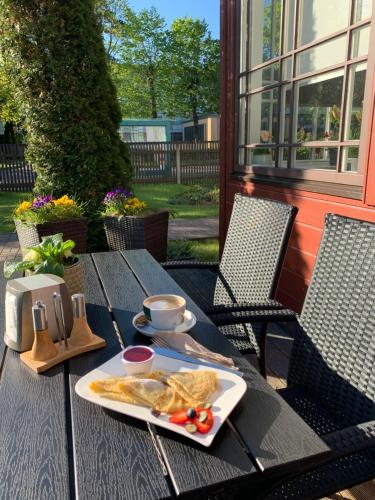 a table with a plate of food on it at Jūras Brīze in Ventspils