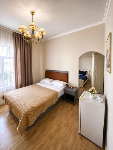 a hotel room with a bed and a chandelier at All residence in Almaty