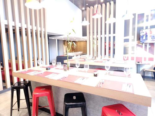 a table with four red stools in a restaurant at ibis Iquique in Iquique