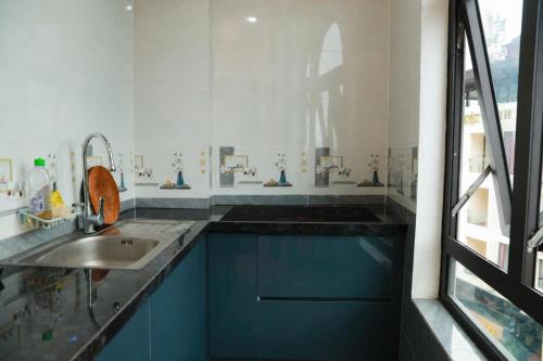 a kitchen with blue cabinets and a sink at Harmony Haven Hotel in Sapa