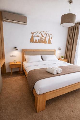 a bedroom with a bed with two towels on it at GERALT Tatras Residence in Nová Lesná