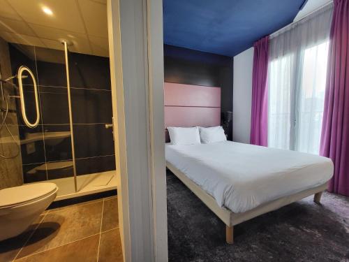 a bedroom with a bed and a shower and a toilet at Accueil Hôtel Paris Pigalle Montmartre - Hôtel rénové in Paris