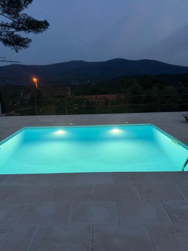 a blue swimming pool with a view of the mountains at Quinta-lina de serpins in Serpins