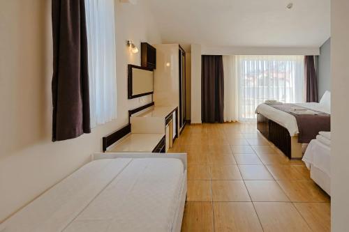 a hotel room with two beds and a window at Nora Suit Hotel in Side
