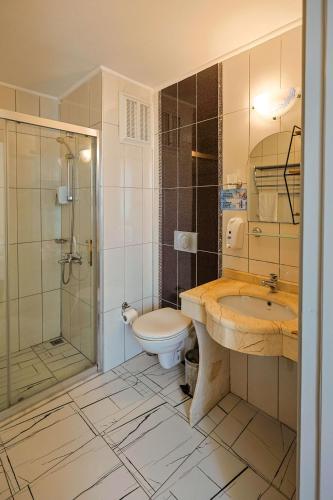 a bathroom with a sink and a toilet and a shower at Nora Suit Hotel in Side