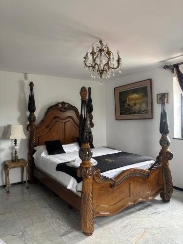 a wooden bed in a room with a chandelier at Canada Castle in Eforie Nord