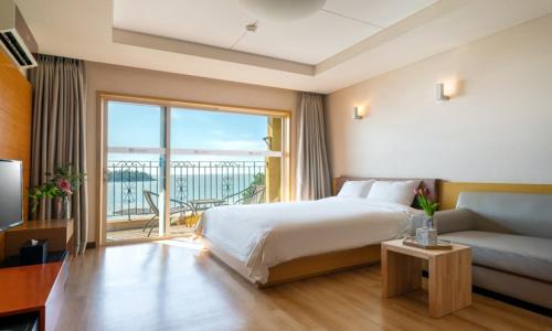 a bedroom with a bed and a couch and a large window at Eldorado Resort in Sinan