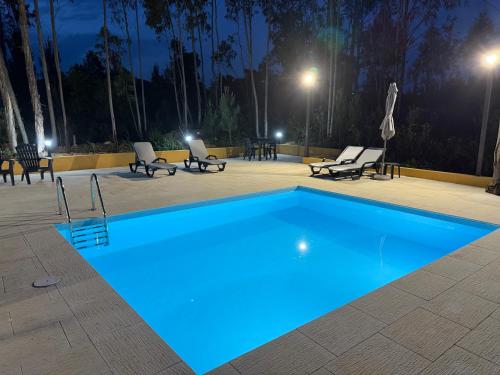 a swimming pool at night with chairs around it at Quinta-lina de serpins in Serpins