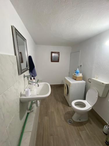 a bathroom with a white toilet and a sink at Papadopoulos House in Kavála