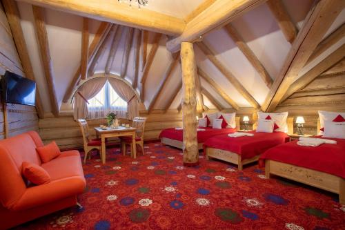 a room with two beds and a table and chairs at Dworek Góralski Restauracja Hotel & SPA in Łodygowice