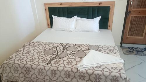a bedroom with a large bed with a bedspread at Hotel Turi & Punjabi Restaurant in Rewalsar