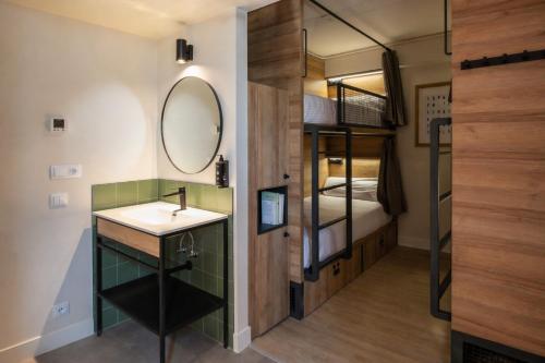 a bathroom with a sink and a mirror and a bunk bed at LATROUPE Grand Place in Brussels