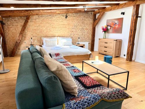 a living room with a couch and a bed at Siesta by Rentoom in Toruń