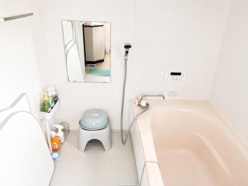 a white bathroom with a tub and a mirror at 宿のきむら2 in Utsunomiya