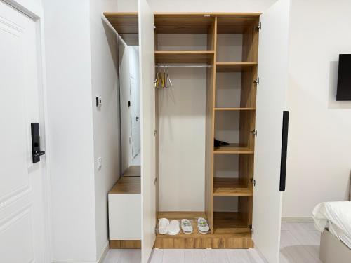 a closet with white walls and wooden shelves at CMC Hotel Apartment in Samarkand