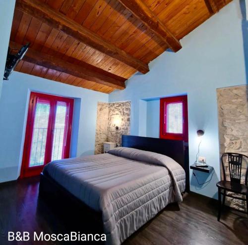 a bedroom with a bed with blue walls and red windows at B&B Mosca Bianca in Ascoli Piceno