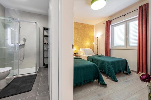 two beds in a room with a shower and a bathroom at Villa Gold Residence 3 in Mlini